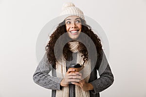 Cheerful young woman wearing winter scarf standing