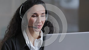 Cheerful young worker business woman girl holding video conference call with client partner wear headphones with