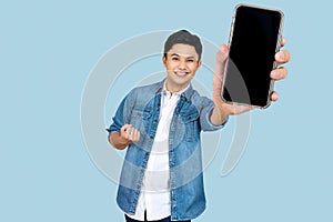 Cheerfull Asian man jumping and smiling in air with showing cellphone blank screen with empty space for mobile app on screen. photo