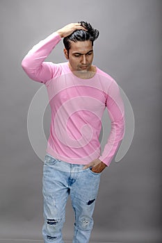 Cheerfull young male model in casual wear wearing pink t-shirt and blue denim jeans. Fitness model. Advertisement shot