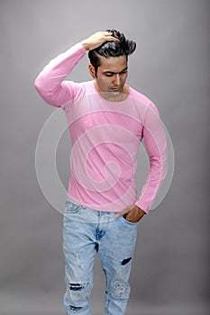 Cheerfull young male model in casual wear wearing pink t-shirt and blue denim jeans. Fitness model. Advertisement shot