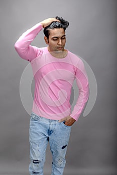Cheerfull young male model in casual wear wearing pink t-shirt and blue denim jeans. Fitness model. Advertisement shot photo
