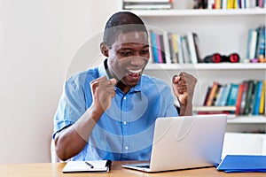 Cheering african american businessman with computer