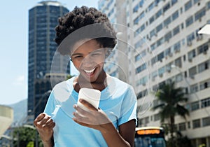 Cheering african american girl with cell phone