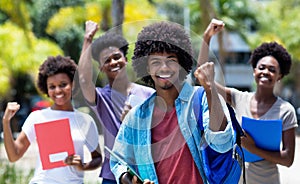 Cheering african american university student with group of african american students