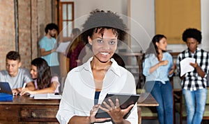 Cheering african american woman with tablet at start up office