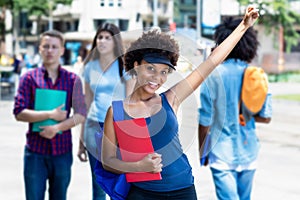 Cheering african american young adult woman with students in city