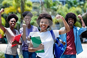 Cheering african amerlcan female university student with group of african american students