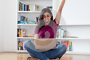 Cheering arabic woman with computer