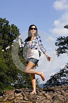 Cheering brunette teenage girl with sunglasses