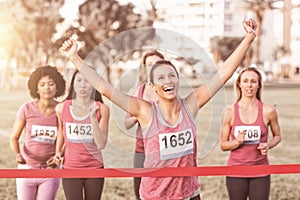 Cheering brunette winning breast cancer marathon