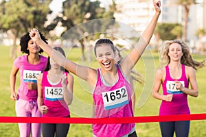 Cheering brunette winning breast cancer marathon