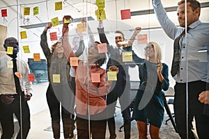 Cheering businesspeople celebrating during an office brainstormi