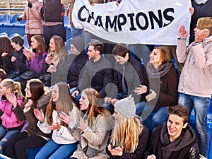 Cheering fans in stadium holding champion banner.