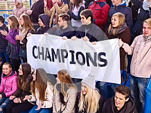 Cheering fans in stadium holding champion banner.