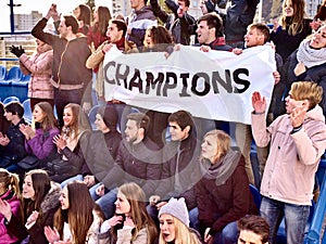 Cheering fans in stadium holding champion banner.