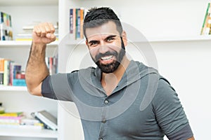 Cheering hispanic mature adult man with beard