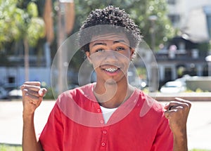 Cheering latin american guy with dental braces photo