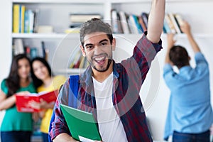 Cheering spanish male student with group of students