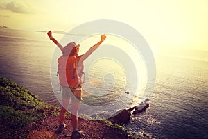 Cheering woman backpacker enjoying the view