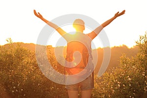 Cheering woman hiker raised arms mountain top