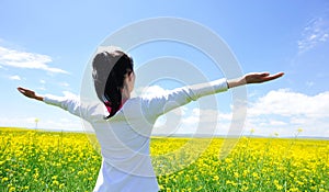 Cheering woman open arms at cole flower field