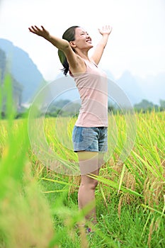 Cheering woman open arms at cole flower field