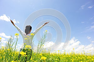 Cheering woman open arms at cole flower field photo