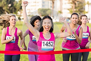 Cheering woman winning breast cancer marathon