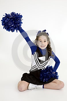 Nine year old Caucasian girl dressed in a blue cheerleader outfit