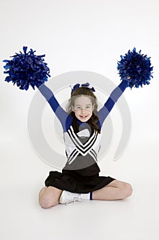 Nine year old Caucasian girl dressed in a blue cheerleader outfit