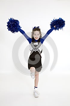 Nine year old Caucasian girl dressed in a blue cheerleader outfit