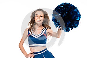 Cheerleader girl in blue uniform holding pompom with hand on hip isolated on white