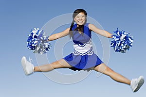 Cheerleader Jumping With Pom-Poms photo