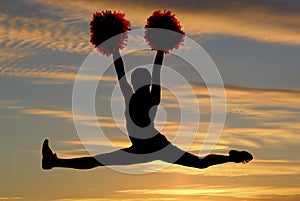 Cheerleader silhouette leaping in air doing the sp photo