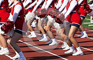 Cheerleaders cheering on the sidlines during a high school football game