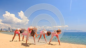 Cheerleaders dance perform high split swing stunt on beach
