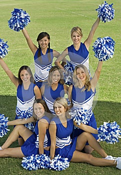 Cheerleaders Holding Pompoms On Field