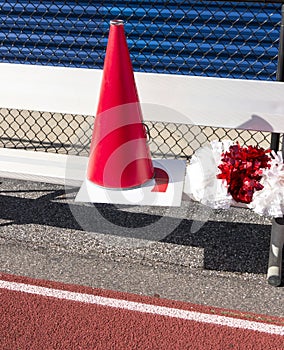 Cheerleaders megaphone, sign and pompoms on a bench