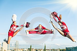 Cheerleaders team performing a Jump with male Coach photo