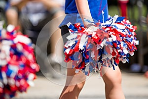 Cheerleaders Waving Red, White, and Blue Pom Poms During Fourth of July Parade