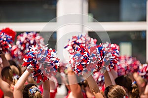 Cheerleaders Waving Red, White, and Blue Pom Poms During Fourth of July Parade