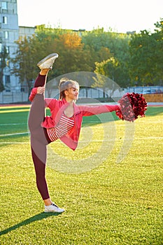 Cheerleading girl in a twine workout, in the morning at sunrise on a field outdoors. Sport, health, fitness