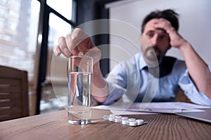 Cheerless depressed man taking medicine