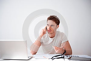 Cheerless handsome man sitting at the table