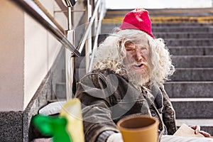 Cheerless homeless man sitting on the street