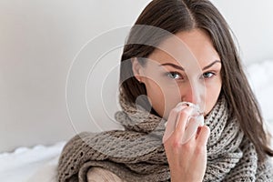 Cheerless ill woman using a paper tissue