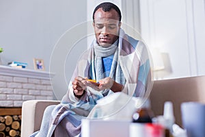 Cheerless sick man looking at his palm