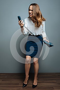 Cheerless stressed woman looking at the phone receiver