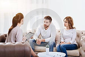 Cheerless young couple visiting a psychologist photo